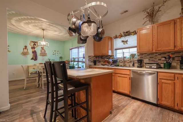 kitchen with visible vents, dishwasher, light wood-type flooring, and light countertops