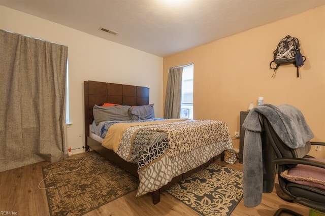 bedroom with visible vents and wood finished floors