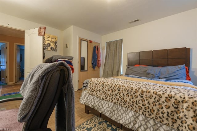 bedroom featuring visible vents, a closet, and wood finished floors