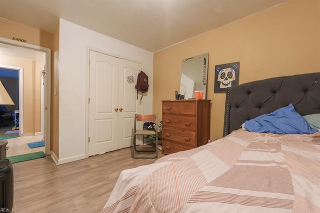 bedroom featuring wood finished floors, a closet, and baseboards