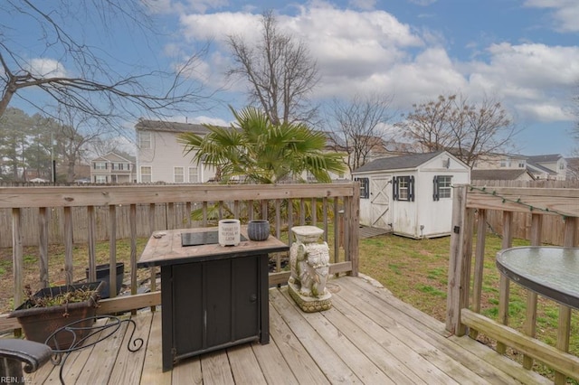 wooden deck with an outbuilding, a storage unit, and fence