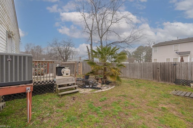 view of yard featuring a deck, central AC unit, and a fenced backyard