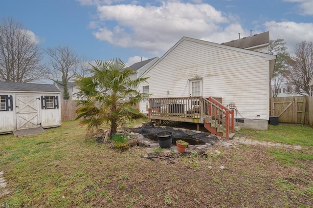 back of house with a lawn, a deck, a fenced backyard, a shed, and an outdoor structure