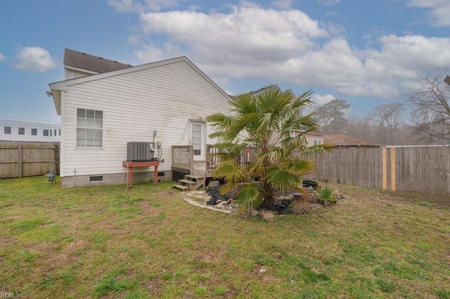 back of house featuring crawl space, a yard, central AC, and fence private yard