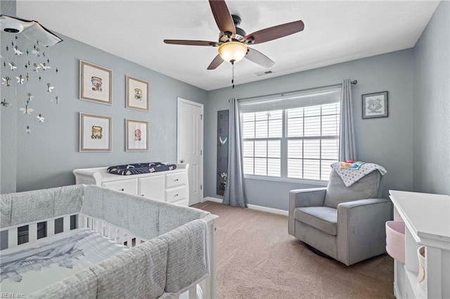 carpeted bedroom with visible vents, a ceiling fan, and baseboards