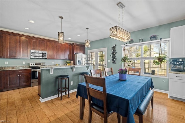 dining area with recessed lighting, light wood-type flooring, and baseboards