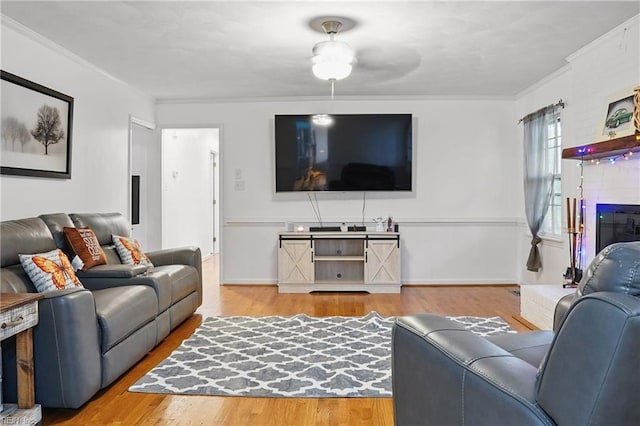 living room featuring baseboards, wood finished floors, and crown molding