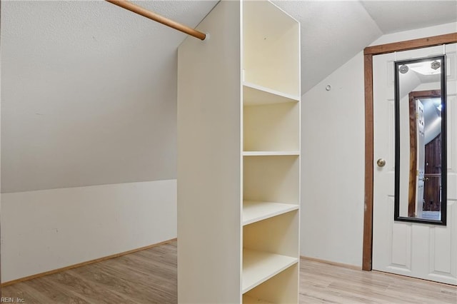 spacious closet featuring lofted ceiling and wood finished floors