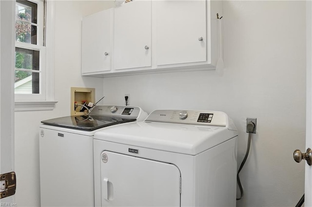 washroom featuring cabinet space and separate washer and dryer