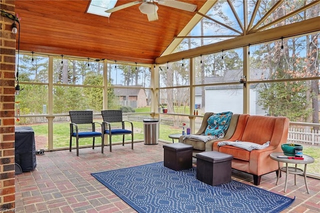 sunroom / solarium featuring lofted ceiling with skylight, wood ceiling, and ceiling fan