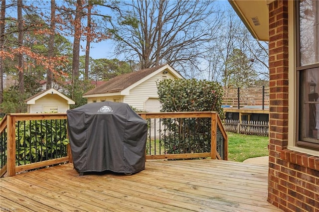 deck featuring an outbuilding, fence, and grilling area