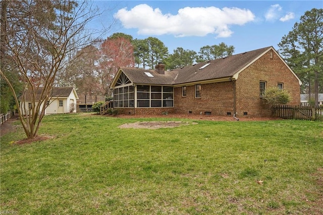 rear view of property with fence, a lawn, a chimney, a sunroom, and crawl space