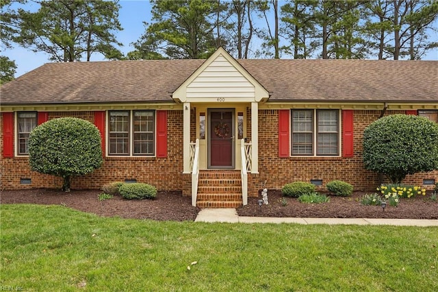 view of front of home with a shingled roof, a front yard, brick siding, and crawl space