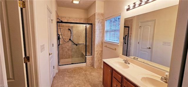 bathroom with a sink, a stall shower, and double vanity