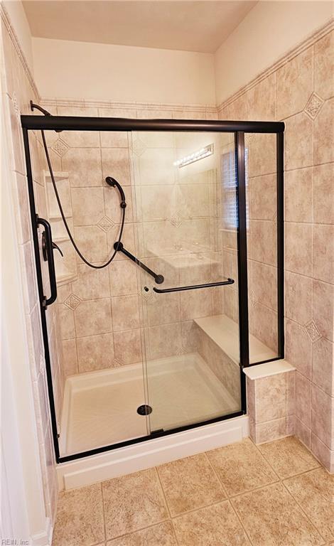 full bathroom with tile patterned flooring and a stall shower