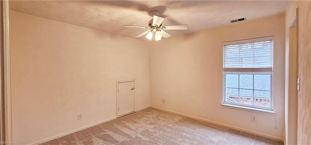 spare room featuring visible vents, light carpet, baseboards, and ceiling fan