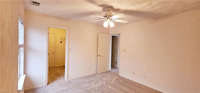 unfurnished bedroom with ceiling fan, light colored carpet, visible vents, and baseboards