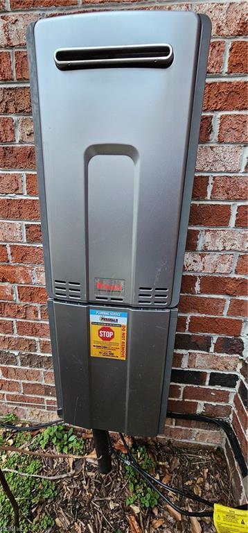 exterior details featuring brick siding and water heater