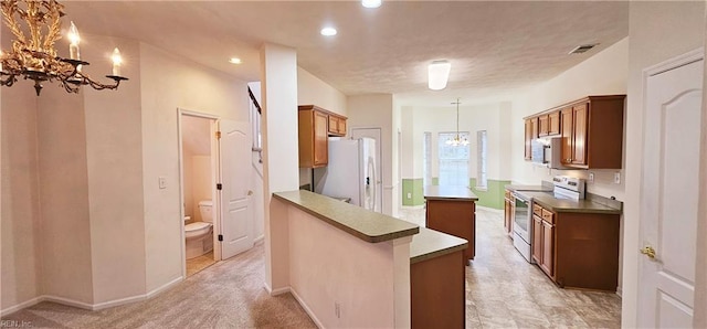 kitchen featuring visible vents, pendant lighting, brown cabinets, an inviting chandelier, and stainless steel appliances