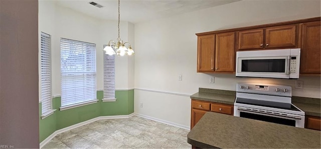 kitchen with white appliances, visible vents, dark countertops, decorative light fixtures, and a notable chandelier