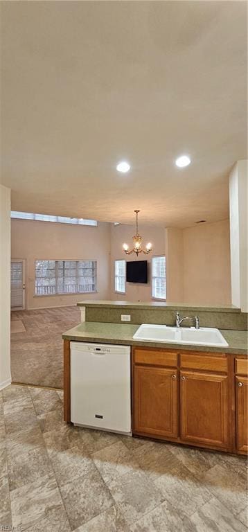 kitchen featuring brown cabinetry, a sink, pendant lighting, dishwasher, and a chandelier