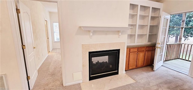 unfurnished living room featuring a multi sided fireplace, light carpet, and visible vents