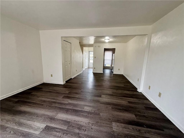 empty room featuring dark wood-style floors and baseboards