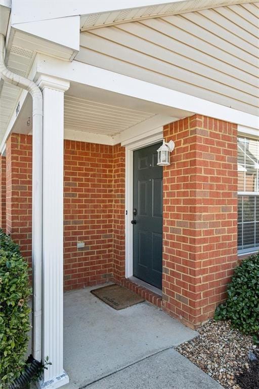 view of exterior entry with brick siding