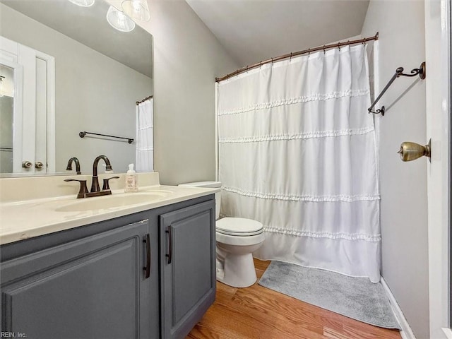 full bathroom with curtained shower, toilet, wood finished floors, and vanity