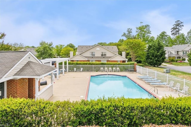 pool with a patio area and fence