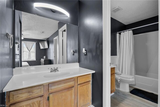 bathroom featuring visible vents, toilet, a textured ceiling, wood finished floors, and vanity