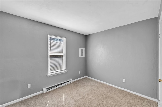 carpeted spare room featuring baseboard heating and baseboards