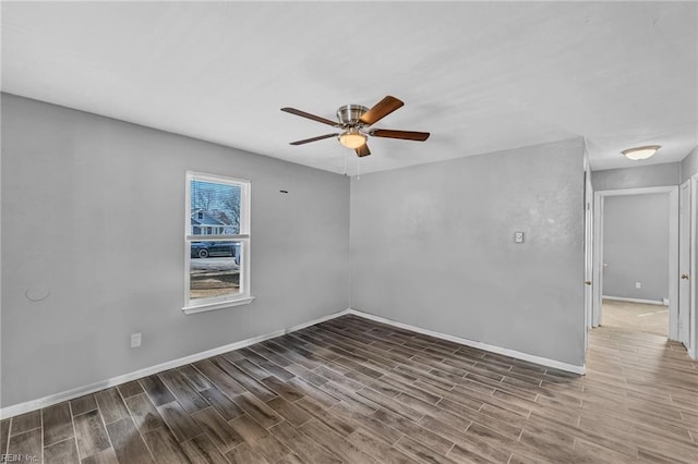 empty room featuring baseboards, ceiling fan, and wood finished floors