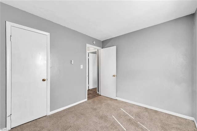 unfurnished bedroom with carpet flooring and baseboards