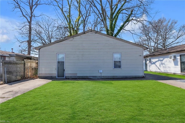 back of house with a lawn and fence