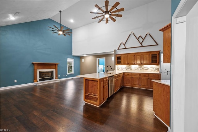 kitchen with stainless steel dishwasher, a peninsula, ceiling fan, and brown cabinetry