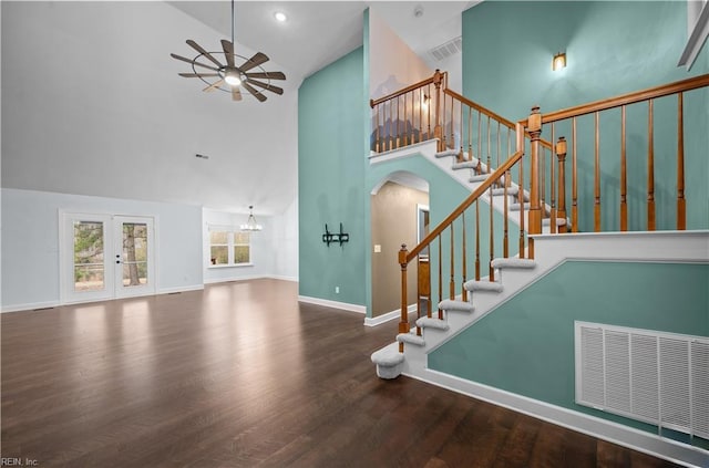 stairway with wood finished floors, visible vents, a ceiling fan, high vaulted ceiling, and arched walkways