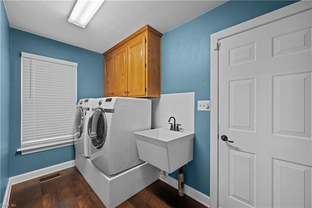 laundry room featuring visible vents, cabinet space, baseboards, and washing machine and dryer