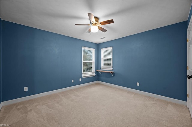 empty room with visible vents, baseboards, carpet, and ceiling fan