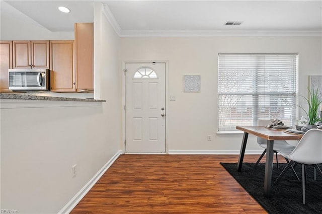 foyer with visible vents, baseboards, dark wood-type flooring, and crown molding