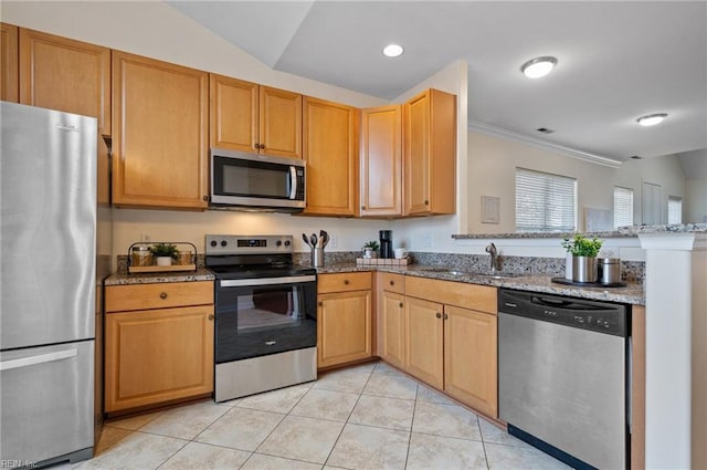 kitchen featuring stone counters, a peninsula, light tile patterned flooring, a sink, and stainless steel appliances