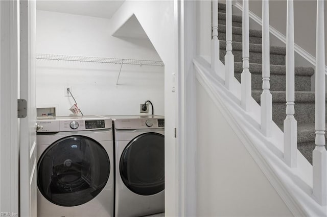 clothes washing area featuring laundry area and washer and clothes dryer