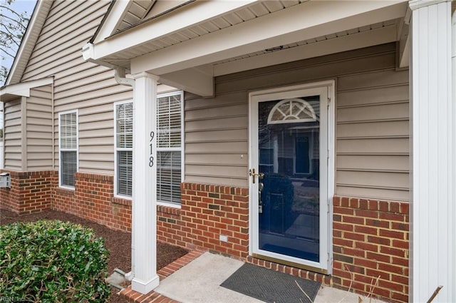 doorway to property featuring brick siding