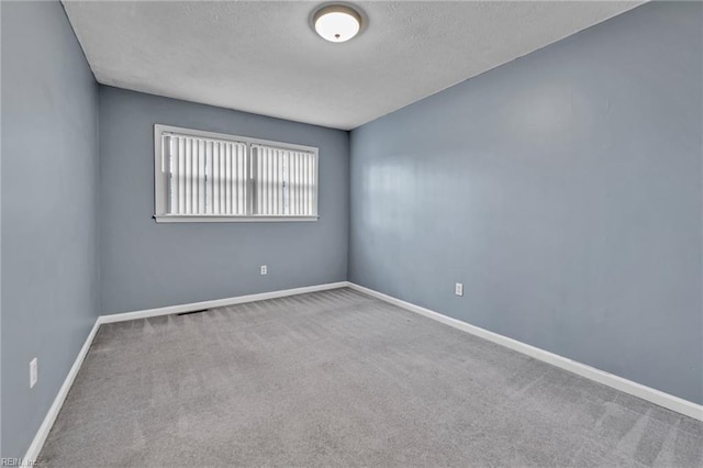 unfurnished room with baseboards, carpet, and a textured ceiling