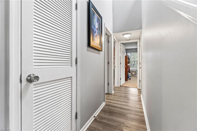 hallway featuring baseboards and wood finished floors