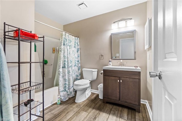 bathroom featuring visible vents, toilet, wood finished floors, baseboards, and vanity