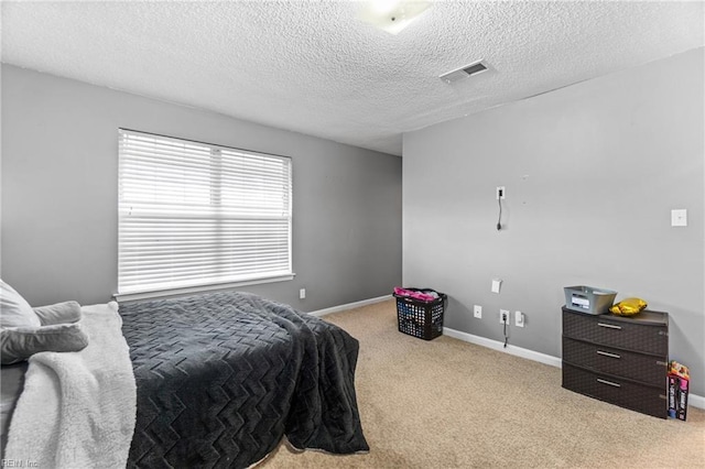 carpeted bedroom with visible vents, a textured ceiling, and baseboards