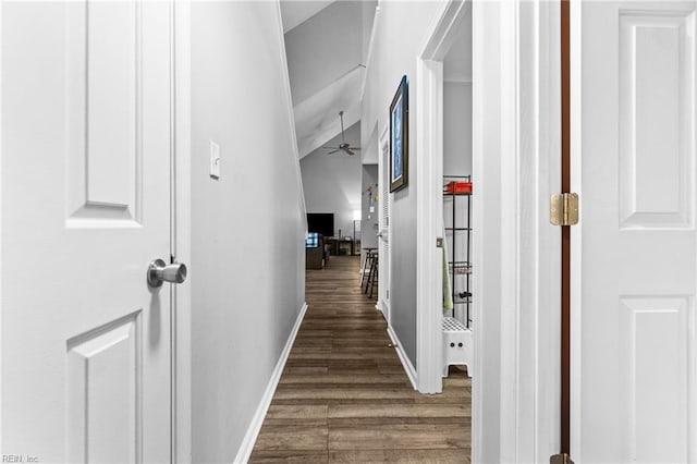 corridor with baseboards and wood finished floors