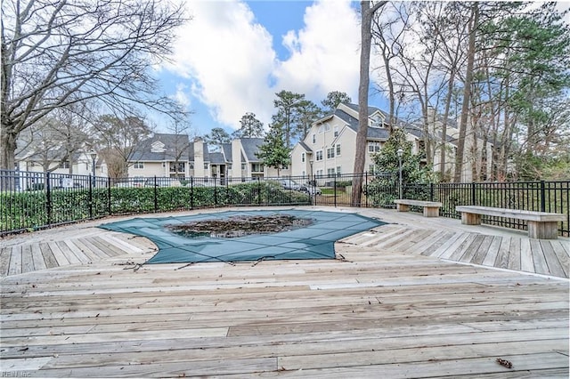 view of swimming pool featuring fence, a fenced in pool, a residential view, and a wooden deck