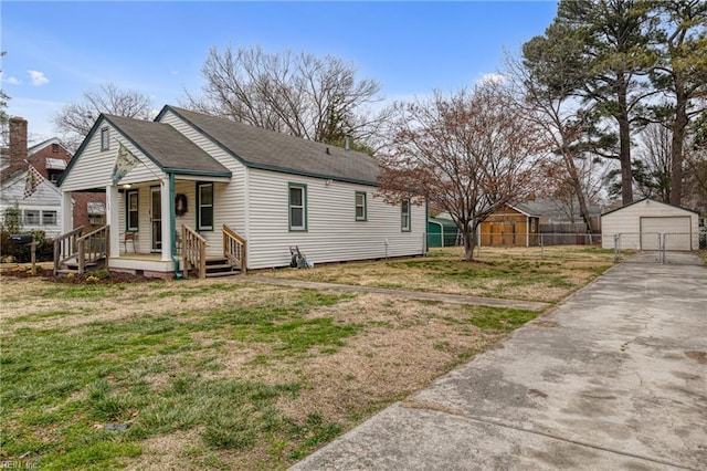 exterior space featuring a porch, fence, a front lawn, and an outbuilding